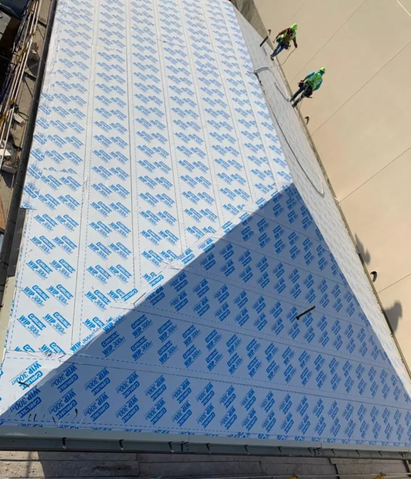 Professional roofers installing underlayment on a metal roof in Liberty